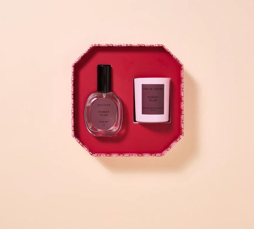 Two perfume bottles in a decorative red box on a beige background