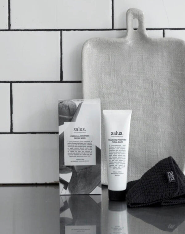 Salus skincare products on a reflective surface with a tiled wall background