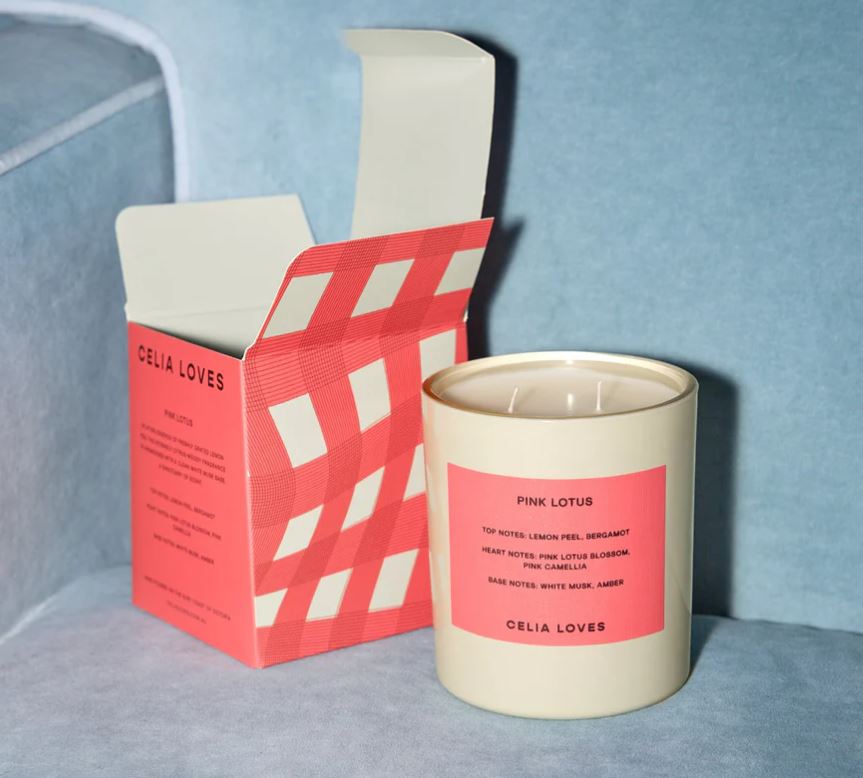 Candle with pink label and packaging on a light blue background