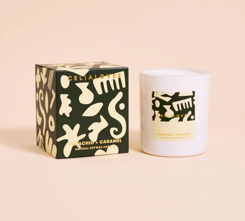 Candle with packaging featuring abstract designs on a beige background