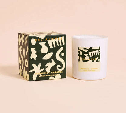Candle with packaging featuring abstract designs on a beige background