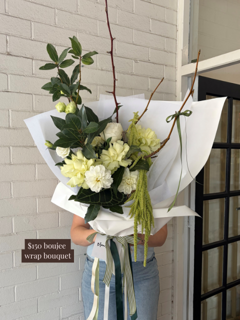 Bouquet of flowers wrapped in paper with a price tag on a neutral background