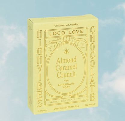 Yellow box of Loco Love High Vibes Chocolate with Almond Caramel Crunch on a blue sky background
