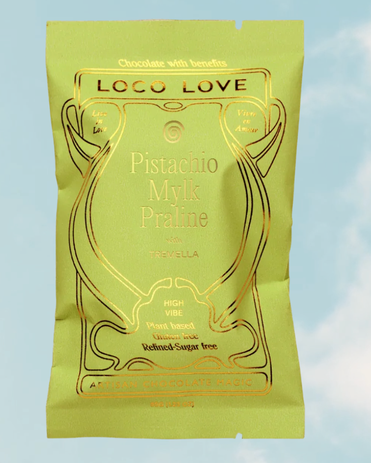 Yellow packaging of Loco Love Pistachio Milk Praline on a light blue background