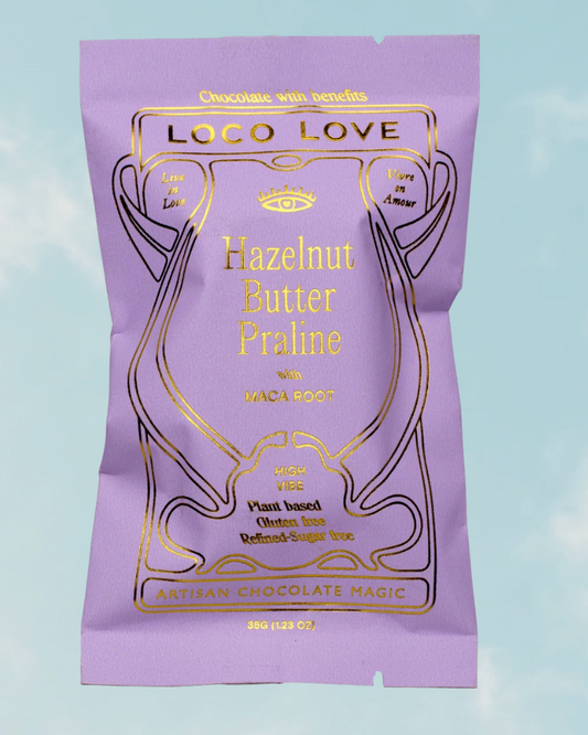 Purple packaging of Loco Love Hazelnut Butter Praline chocolate on a light blue background