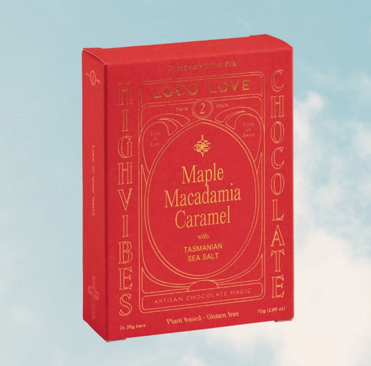 Red box of Highvibes Maple Macadamia Caramel chocolate with a blue sky background