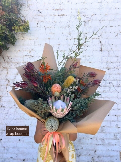 A bouquet of native flowers against a white brick wall