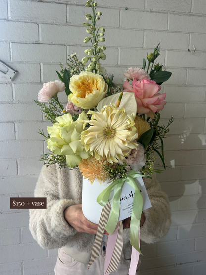Bouquet of flowers held by a person against a white brick wall